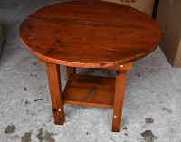 Round pine side table shown from a top angle highlighting wood grain and table top surface condition.