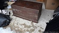 Overall view of the rectangular pine blanket box showing dark brown staining, scuff marks, and top and sides.