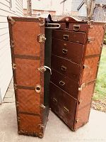 Front-open view showing interior with stacked drawers on right and fold-out hangers on left