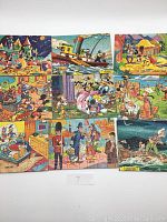 Overhead photo showing all nine Walt Disney puzzles laid out in a grid pattern, showcasing colorful cartoon scenes from vintage TV series