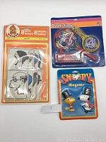 Front view of the lot showing party favors, noise makers, and Snoopy magnets in packaging