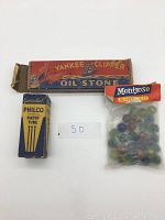 Photo of all three items: the Philco radio tube box, the Yankee Clipper oil stone box, and a sealed bag of Montrose glass marbles.