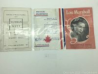 Photo of three vintage paper pamphlets laid side by side in plastic protective sleeves: Russian Nite 1945, Musical Manifesto, Lois Marshall Soprano 1950.