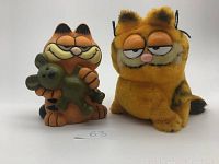 Two vintage Garfield toys side by side on white background with handwritten 63