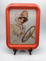 Front view of vintage Coca Cola tray with orange border and image of woman holding a Coca Cola bottle.