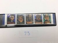 Photo of five 32-cent USA classic Halloween monster stamps featuring Dracula, Frankenstein, Mummy, Wolf Man, and Phantom of the Opera, all in a protective sleeve.