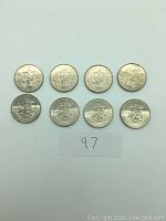 Eight 1984 Canadian silver dollar coins arranged in two rows on a white background, showing overall lot quantity and condition.