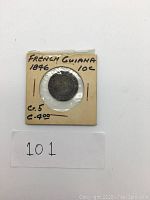 Front view of the 1846 French Guiana 10 cent coin in cardboard holder showing inscriptions and condition.