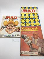 Two Mad Magazine issues and one Newsweak parody cover laid side by side on a light surface.