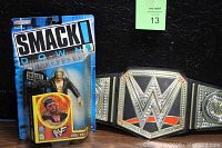 Photo showing WWF Smack Down action figure M.O.C. packaged alongside the World Heavyweight Champion belt.