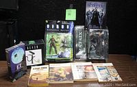 Full lot overview showing all science fiction collectibles including action figures, VHS, DVD, and paperbacks.
