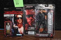 Photo showing the McFarlane Toys T-850 Terminator action figure with coffin accessory and the ReAction Terminator figure in their original packaging.