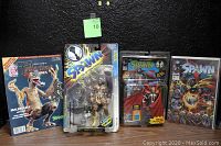Photo showing four collectible items: White's Guide to Collecting Figures magazine on the left, Todd McFarlane Spawn Renegade Ultra Action Figure in original packaging second from left, Image Spawn Comic Book #13 bagged and carded second from right, and Todd McFarlane's Spawn Poseable Action Figure with Special Edition Spawn #1 comic book MOC on far right.