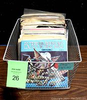 Metal wire basket filled with sleeved 45 RPM records, front cover showing "Escape From the Gremlins" storybook and CD.