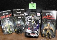 Four horror collectible action figures sealed in original packaging displayed against a black background. Left to right: Jason Voorhees from Friday the 13th, Pinhead from Hellraiser III, Lunabella Whispers from Begoths Series 4, Freddy Krueger from A Nightmare on Elm Street.