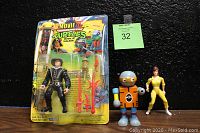 Three action figures shown: 1992 TMNT Movie III Walker figure in original blister packaging with weapons and card, standing outside are April O'Neil figure in yellow outfit and Toysmith wooden turtle figure.