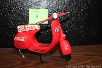 Front view of the red Coca-Cola scooter model showing detailed handlebar, white polka dot seat, and Coca-Cola logo on rear body.