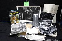 Overview photo showing the Blue Feather book, several black-and-white photographs including a large family group photo, landscape, and other scenes, spread out on a flat surface.