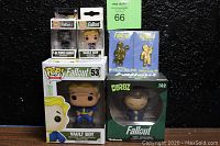 6 Fallout-themed collectible vinyl figures and pins in original packaging, displayed against black background.