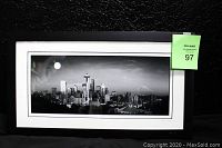 Full view of the framed black and white panoramic photograph showing a city skyline with a moon, labeled with lot number.
