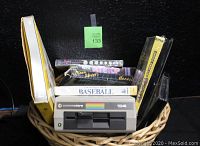 Overview showing Commodore 1541 disk drive and boxed software and games in basket