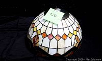 Full view of the stained glass lampshade showing geometric pattern with brown, beige, cream, and orange colors.