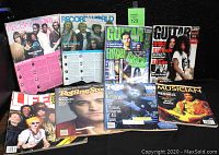 Photo displaying all 8 vintage music magazines arranged in two rows on a black surface