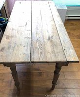 Top-down angle showing entire table top of wood plank construction and surface wear