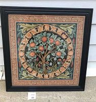 Overall front view of tapestry in black frame showing circular orange tree design with patterned border.