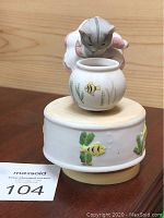 Full view of the Schmid windup musical ornament showing the cat leaning over the fishbowl on the base.