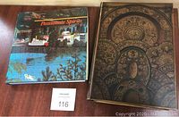 Photo showing two books side by side: the art book Passionate Spirits with a colorful cover and the decorative fake book with an ornate design.