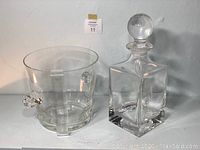 Photo showing the clear glass ice bucket with rolled glass handles and the square etched glass decanter with large round glass stopper.