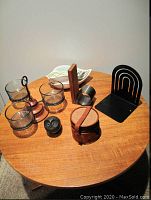 Photo showing Danish condiment holder with glass dishes on copper stand, black Spectrum bookend, Danish leather coasters in holder, and two hand-painted Italian ceramic bowls.