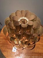 Top-down angled photo of gold plastic pendant shade showing multiple curved petals and layered structure.