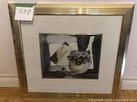 Full view of framed multimedia artwork featuring gold foil, with visible off-white mat and gold trim frame.