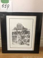 Full view of black Umbra plastic frame housing the print of La Maison Chevalier, Quebec by Vogel. Frame shows possible scratches/marks.