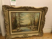 Full view of framed painting showing landscape scene and frame style