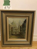 Framed original oil painting showing full framed artwork with painting of Saint Pauls Cathedral and surrounding buildings in muted tones.