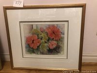 Framed watercolour painting of hibiscus flowers, showing entire frame and matting with a floral image inside.