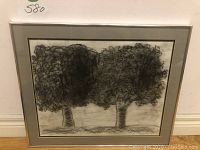 Framed charcoal or pencil drawing depicting two trees with curly foliage and textured trunks, signed by artist Kelly, measurement of 21 x 17 inches for frame, 17 x 13.5 inches for artwork.