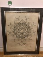Full view of framed intricate circular geometric sketch mounted on cream paper, signed by artist, dark wood frame with glass, minor damages to backing and glass