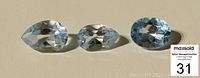 Three faceted aquamarine gemstones arranged side by side showing front face with light blue color and faceting details.