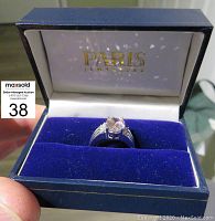 Silver ring with a rose quartz center stone in a blue velvet PARIS Jewelers box.
