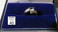 Ring displayed in blue velvet jewelry box with Paris Jewellers imprint.