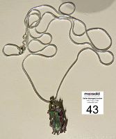 Full view of the silver snake chain with attached mystic topaz pendant.