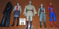 Five 12-inch vintage action figures standing upright on a brown surface including Kylo Ren, Princess Leia, Obi-Wan Kenobi, Rey, and Spider-Man