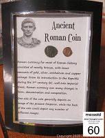 Photo of framed Roman coins with information about Roman coinage history and material composition.