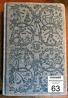 Front cover of antique 1915 Little Women book showing detailed black illustrations on gray hardcover.