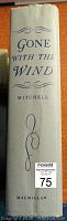 Spine of the vintage "Gone with the Wind" book showing the title, author (Mitchell), and publisher (Macmillan) in blue print on a cream or light-colored background.