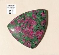 Top view of the triangular ruby in fuchsite pendant showing pink ruby inclusions in green fuchsite matrix.